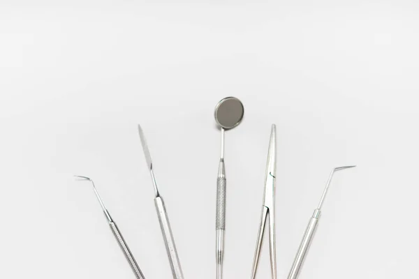 Strumenti dentali sterili sdraiati su sfondo bianco — Foto Stock