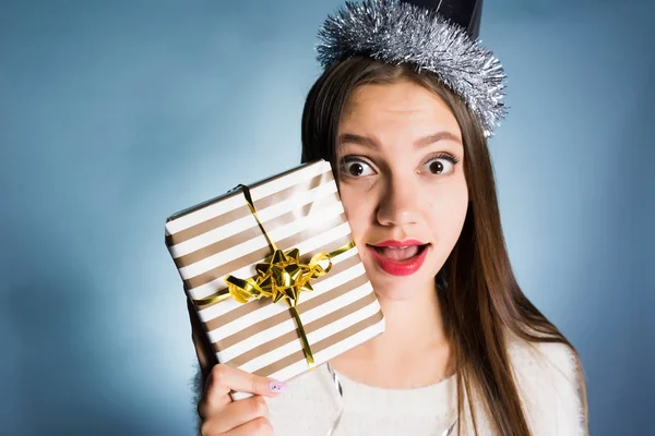 Vrouw in feestelijke hoed houdt een geschenk in handen — Stockfoto