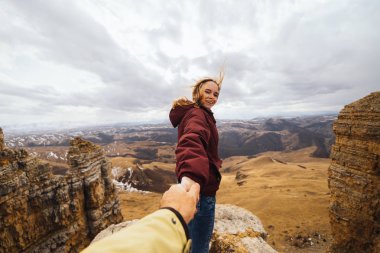 adam bir kadın eli Dağları arka planı tutar.