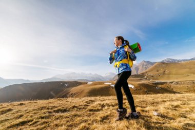 kadın turist arka planda dağların büyük bir sırt çantası ile