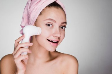 kadının kafasındaki bir havlu ile derin temizleme için bir fırça ile yüz temizler