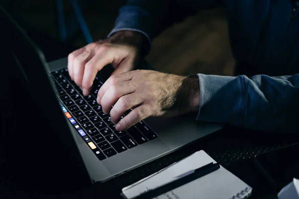 Haker człowiek pisze coś na klawiaturze — Zdjęcie stockowe