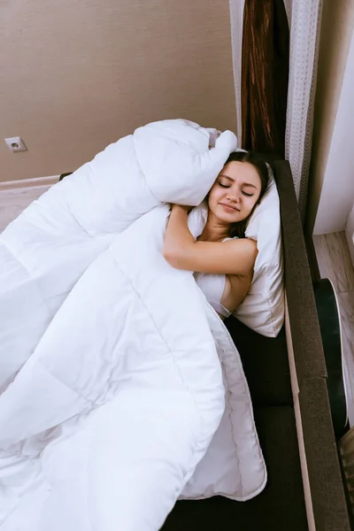 Una donna dorme su un letto sotto una coperta — Foto Stock