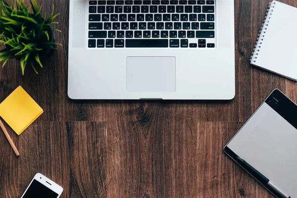 Op een houten tafel liggen een laptop, telefoon, laptop — Stockfoto