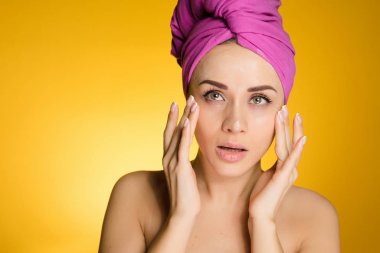 Kadın sarı bir arka plan karşı kafasındaki bir havlu ile