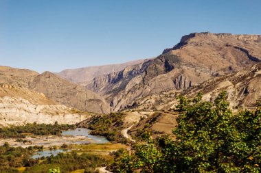 güneşli bir gün nehire karşı yüksek dağlar
