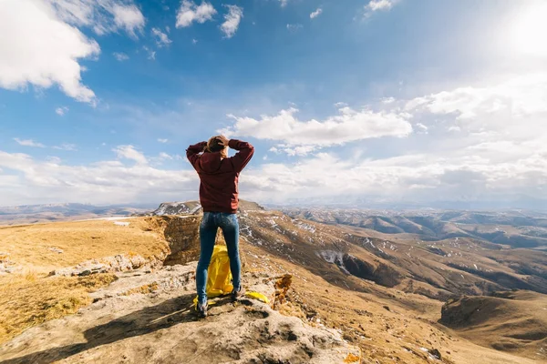 Woman tourist standing against the background of high mountains — Stock Photo, Image