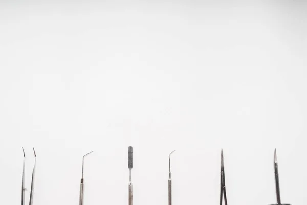 Kit de ferramentas estéril dental encontra-se em um fundo branco — Fotografia de Stock