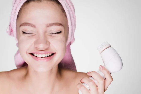 Счастливая женщина с полотенцем на голове держит в руке кисть для глубокой очистки — стоковое фото