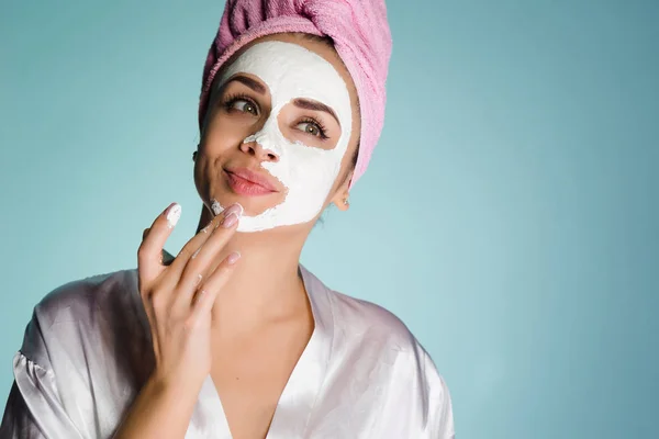 Женщина с полотенцем на голове нанести маску, чтобы очистить лицо — стоковое фото