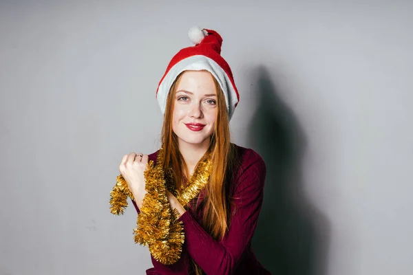 Femme dans un chapeau de Noël sur un fond gris — Photo