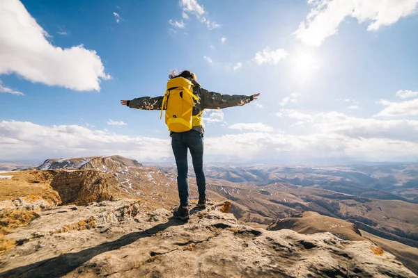 Жінка-турист з великим рюкзаком стоїть серед високих гір — стокове фото