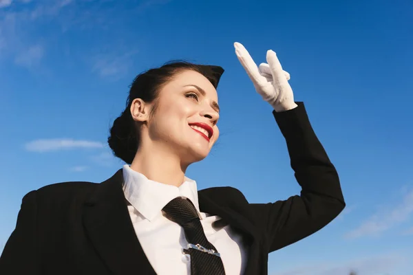 Glücklich Stewardess in Uniform auf dem Himmel Hintergrund — Stockfoto