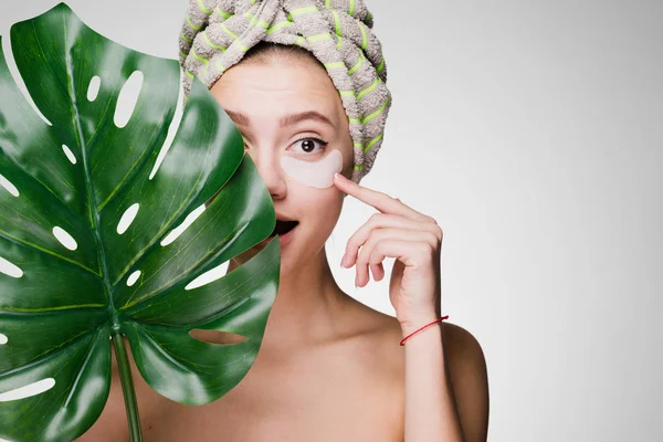 bir kadının kafasındaki bir havlu ile yamalar gözleri altında koymak.