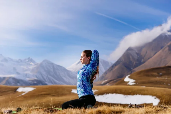 Женщина-турист, практикующая йогу на фоне гор — стоковое фото