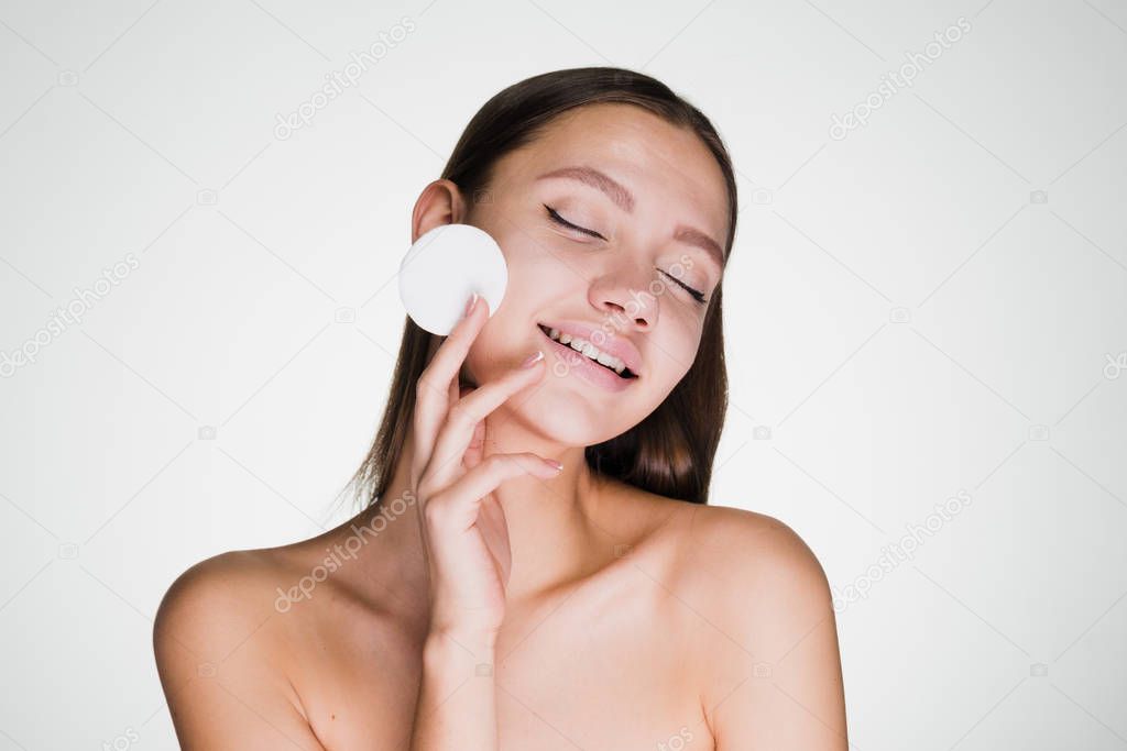 happy woman after shower holding a cotton ball in her hand