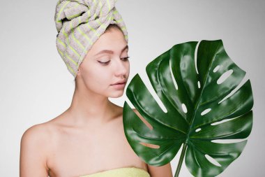 kadının kafasındaki bir havlu ile onun elinde büyük bir yaprak tutar.