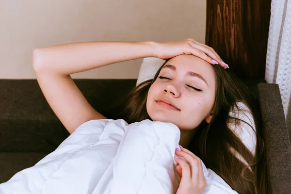 Frau mit langen Haaren schläft auf dem Bett unter der Decke — Stockfoto