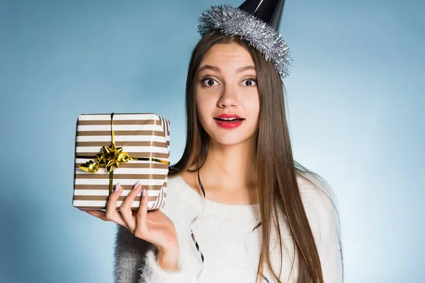 Женщина в праздничной шляпе держит в руках подарок — стоковое фото