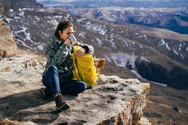 kadın turist Dağları arka plan üzerinde sıcak çay içer