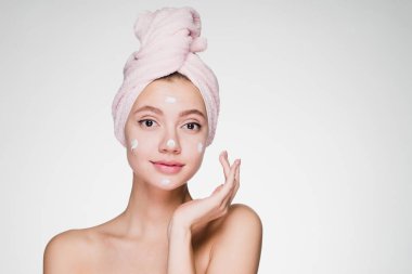 kadının kafasındaki bir havlu ile krem yüz cilt üzerinde geçerlidir.