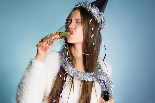 Пьяная женщина в праздничной шляпе пьет шампанское — стоковое фото
