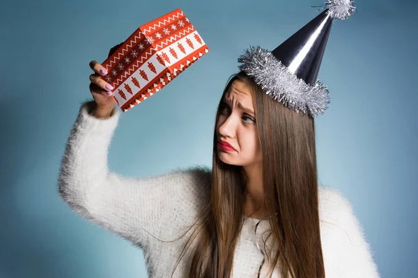 Mulher triste no gorro festivo segurando caixa de presente vazia — Fotografia de Stock