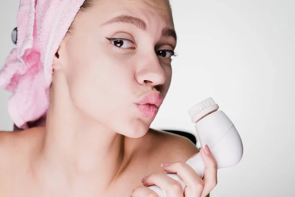 Donna con un asciugamano sulla testa tiene in mano una spazzola per la pulizia profonda — Foto Stock