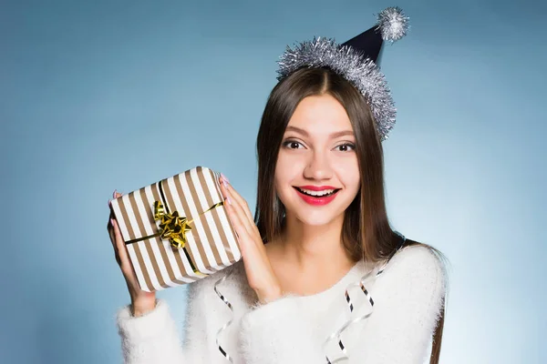 Счастливая женщина в праздничной шляпе держит в руках подарок — стоковое фото
