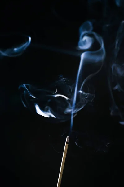 Palo de incienso fuma sobre un fondo oscuro — Foto de Stock