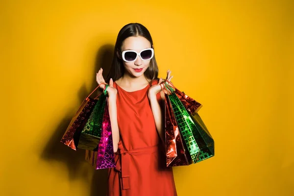 Vrouw in een mooie jurk houdt boodschappentassen — Stockfoto