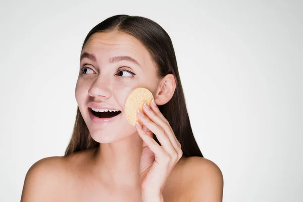 Glückliche Frau reinigt das Gesicht mit einem Schwamm — Stockfoto