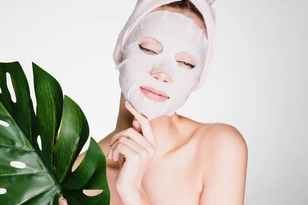 Kvinna med en handduk på huvudet tillämpas en mask på ansiktet — Stockfoto
