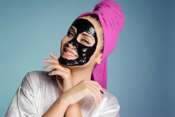 Femme heureuse avec une serviette sur la tête appliquer un masque nettoyant sur la peau du visage — Photo