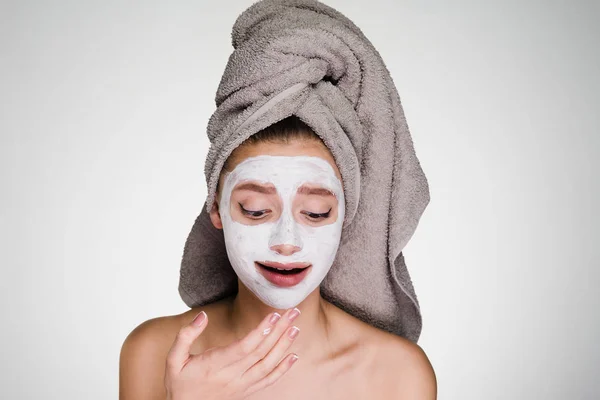 Wanita dengan handuk di kepalanya telah menempatkan masker di wajahnya — Stok Foto