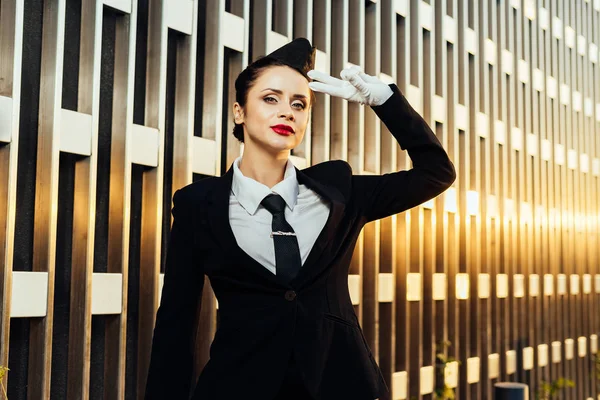 Femme hôtesse de l'air en uniforme posant sur fond de bâtiment — Photo