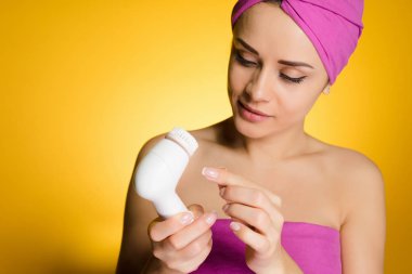 kadının kafasındaki bir havlu ile derin temizleme için bir fırça tutar