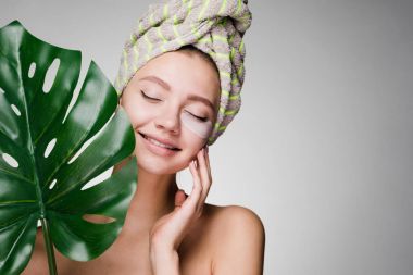 Gözlerinin altında yamalar başında bir havlu ile mutlu kadın vurdu