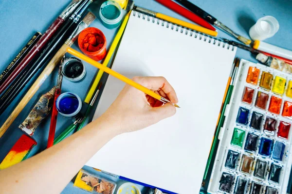 Γυναίκα ζωγράφος ζωγραφίζει πολύχρωμα χρώματα σε ένα λευκό φύλλο χαρτί — Φωτογραφία Αρχείου