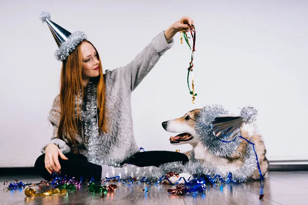 Femme dans une casquette festive jouer avec un chien — Photo