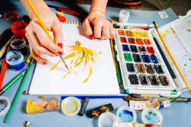 Beyaz bir kağıt üzerine renkli boyalar kadın ressam boyalar