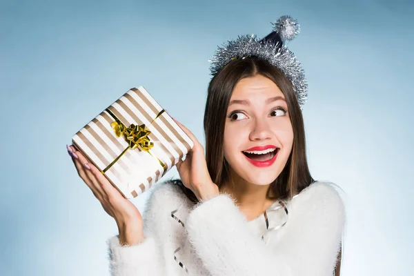 Gelukkige vrouw in een feestelijke hoed houdt een geschenk in haar handen — Stockfoto