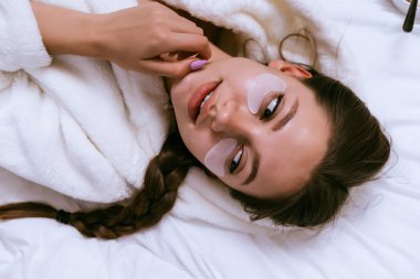 bir kadın yamaları gözlerini ve yalanlar altında yatağın üstüne koy.