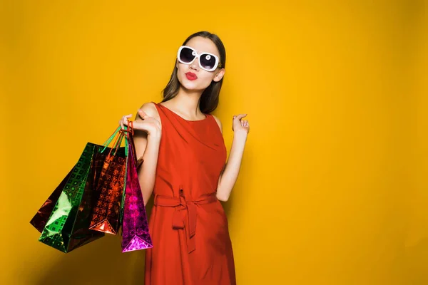 Frau im schönen roten Kleid hält Einkaufstüten — Stockfoto