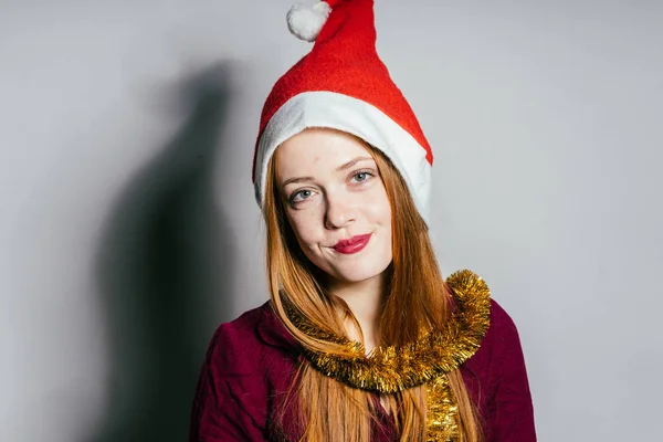 Жінка в різдвяному капелюсі на сірому фоні — стокове фото