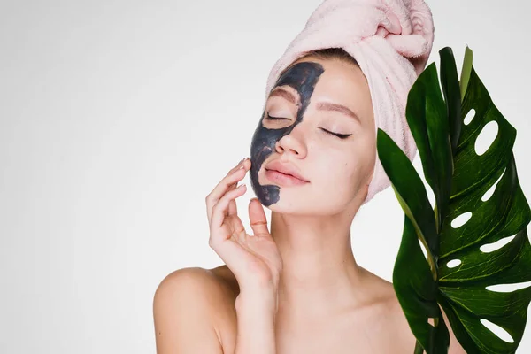 Nő fején egy törülközővel alkalmazni a tisztító maszk az arc bőrén — Stock Fotó
