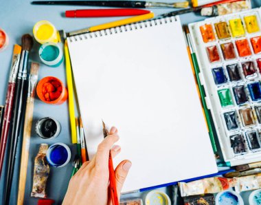 mavi bir tabloda sanat malzemeleri yatıyordu, kağıt ve parlak renk beyaz