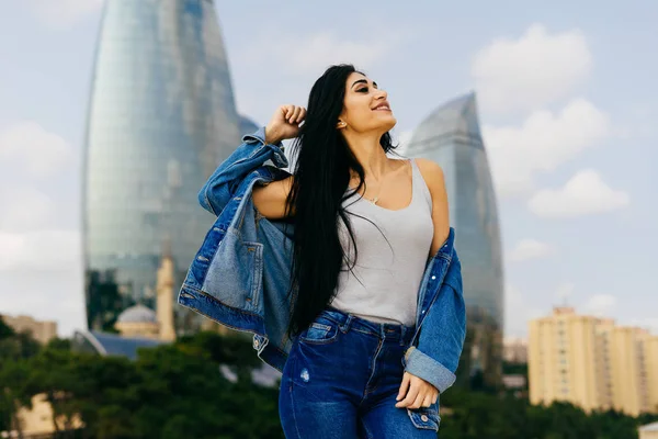 Attractive young black-haired girl doing selfie on the background of modern buildings in Baku — Stock Photo, Image