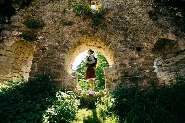 Junges Mädchen posiert in einer alten Ruine, umgeben von viel Grün — Stockfoto
