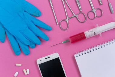 tıp aletleri, eldiven ve bir akıllı telefon, beyaz bir dizüstü ve tablet bir pembe yalan
